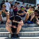 Adolescentes con el móvil en el Estanque del Retiro de Madrid.
