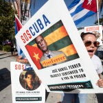 Los Angeles (United States), 08/06/2022.- A protester holds a poster reading 'SOS Cuba' and displays the portrait of a Cuban allegedly wrongfully imprisonned by the regime, as they gather in front of the Microsoft Theater, where leaders and heads of delegations arrive for the inaugural ceremony of the 2022 Summit of the Americas, in Los Angeles, California, USA, 08 June 2022. (Protestas, Estados Unidos) EFE/EPA/ETIENNE LAURENT