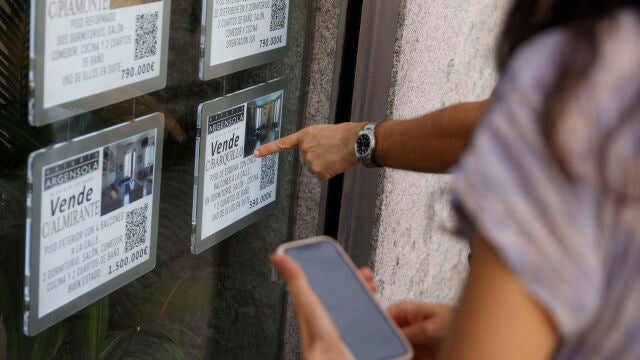 Unas personas se paran delante del escaparate de una inmobiliaria