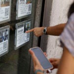 Unas personas se paran delante del escaparate de una inmobiliaria
