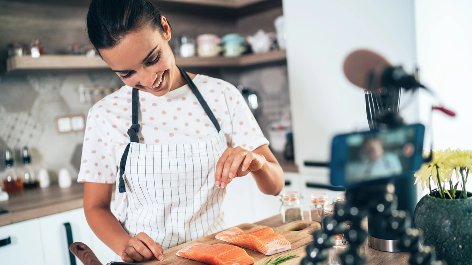 Imagen de mujer cocinando grabando un vídeo.