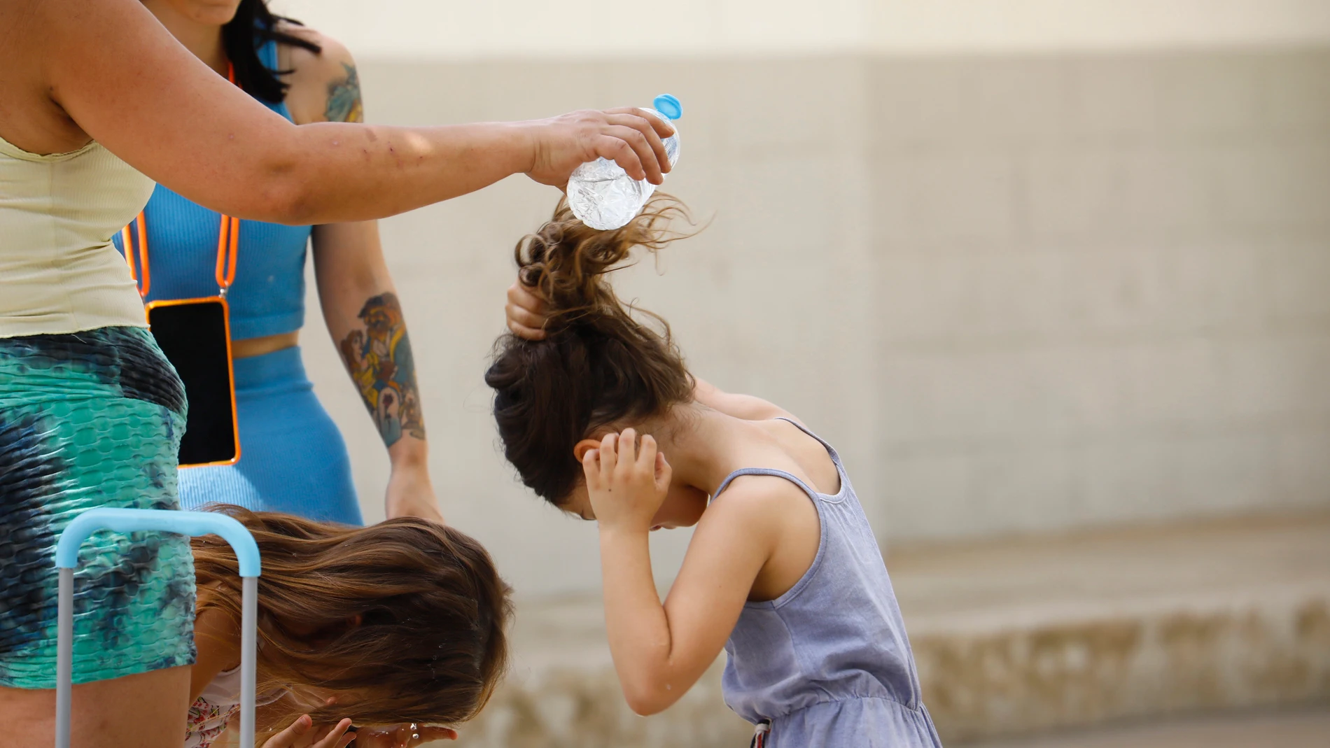 Varias madres del colegio Mediterráneo de Córdoba refrescan a sus hijos con botellas de agua