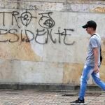 AME7899. BOGOTÁ (COLOMBIA), 20/06/2022.- Un hombre camina frente a un grafiti de "Petro presidente", hoy, luego de la celebración en la Plaza de Bolívar tras la elección del izquierdista Gustavo Petro como presidente para el periodo 2022-2026, en Bogotá (Colombia). El próximo 7 de agosto Petro será investido como sucesor del presidente Iván Duque, con el cual se cerrará un ciclo de más de 200 años de gobiernos de derechas. La elección de Petro, de quien se espera que empiece a dar nombres sobre su equipo de Gobierno, da inicio en el país a un periodo de cambios políticos, económicos, sociales y ambientales. EFE/ Carlos Ortega