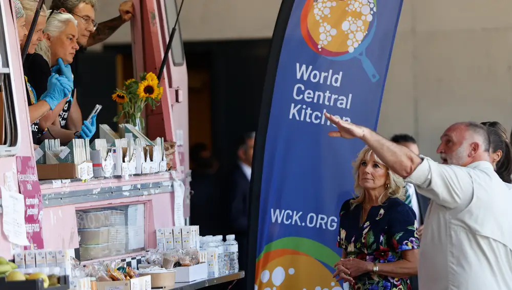 La reina Letizia y la primera dama de EE UU, Jill Biden (i), junto al chef José Andrés (d), conversan con los encargados del food truck de la ONG World Central Kitchen (WCK), de José Andrés, este martes en Pozuelo de Alarcón (Madrid)