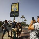 Unos turistas se fotografían debajo de un termómetro de calle que marca 45 grados, hoy en Córdoba