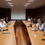 A la izquierda, el consejero Rogelio Velasco y el viceconsejero de Presidencia. A la derecha, miembros del comité de empresa de Abengoa, este jueves en Sevilla