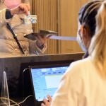 Una mujer enseña su tarjeta sanitaria para realizarse un tes de antígenos en el Recinto Modernista del Hospital de Sant Pau de Barcelona, Cataluña (España)