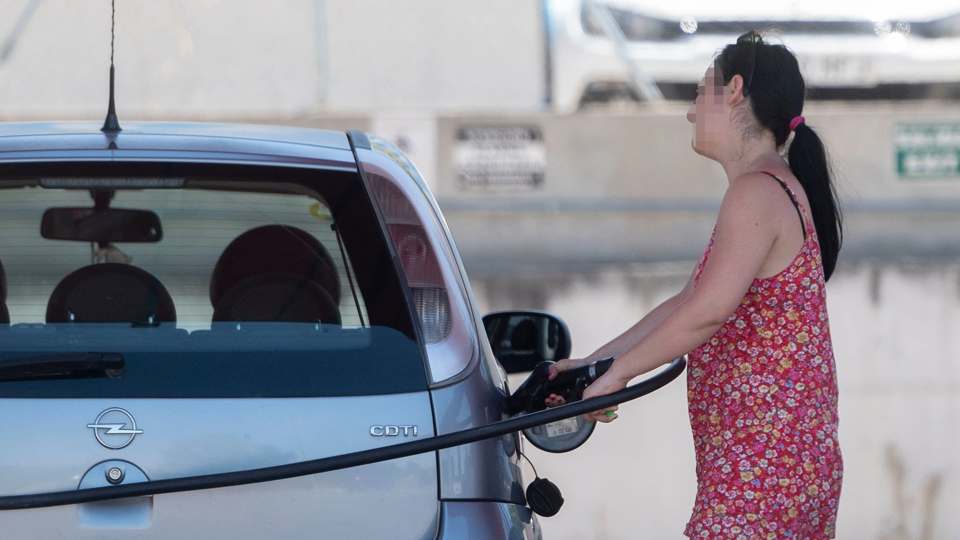 Una pasajera reposta en una gasolinera a la altura de Rivas (Madrid), durante la primera operación salida del verano de 2022, a 1 de julio de 2022