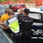 Imagen de uno de los detenidos, custodiado por la Policía Nacional