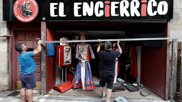 Dos trabajadores realizan pruebas para la colocación de un vallado en una tienda de la calle de Mercaderes por donde discurrirían los encierros de estos Sanfermines 2022. EFE/ Jesús Diges