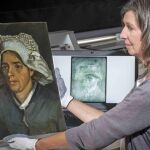 La conservadora Lesley Stevenson, sosteniendo la obra de la campesina que ocultaba el autorretrato de Van Gogh