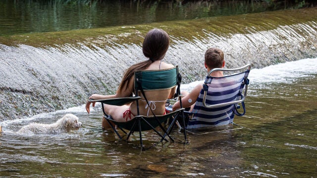 Unos jóvenes se refrescan en el río Iregua a su paso por Logroño el pasado mes de julio