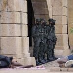 Soldados del ejército hacen guardia mientras los manifestantes duermen junto a la entrada de la oficina del presidente en Colombo, Sri Lanka