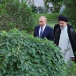 Imagen ofrecida por el Gobierno iraní en la que se observa al presidente Ebrahim Rais con su homólogo ruso caminando en el jardín en Teherán