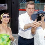 El presidente del Partido Popular, Alberto Núñez Feijóo, se fotografiía con dos turistas este viernes en Benidorm donde se ha reunido con representantes del sector turístico