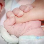Fotografía de la mano de un bebé agarrando un dedo