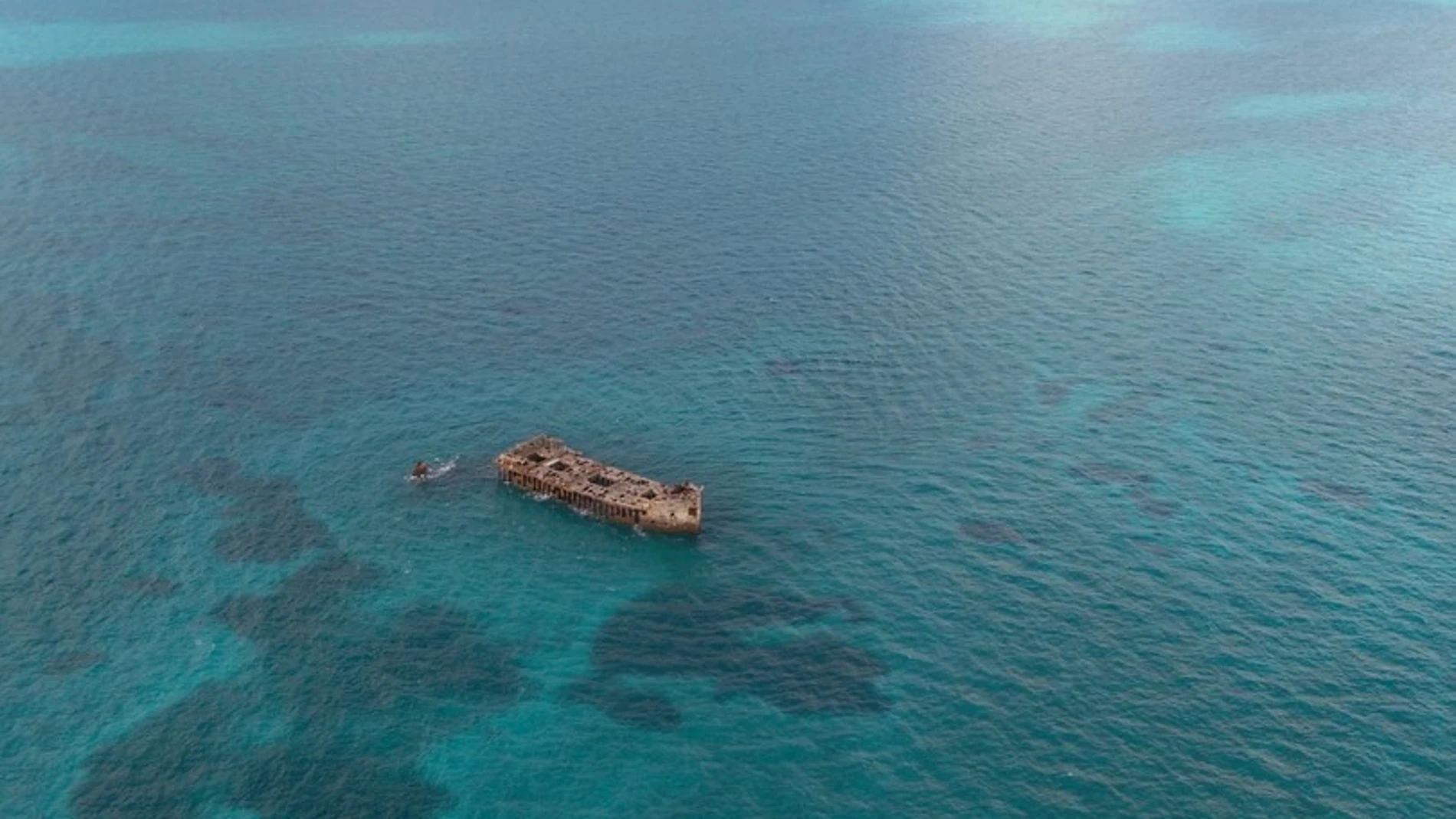 Barco naufragado en medio de una gran extensión de mar