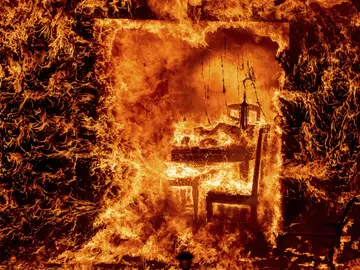 Las llamas envuelven una silla dentro de una casa en llamas mientras arde el incendio de Oak en el condado de Mariposa Las llamas envuelven una silla dentro de una casa en llamas mientras arde el incendio de Oak en el condado de Mariposa