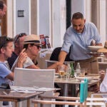 Un camarero sirve varias bebidas en una terraza