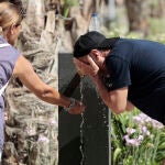 Dos personas se refrescan en una fuente del centro de Valencia