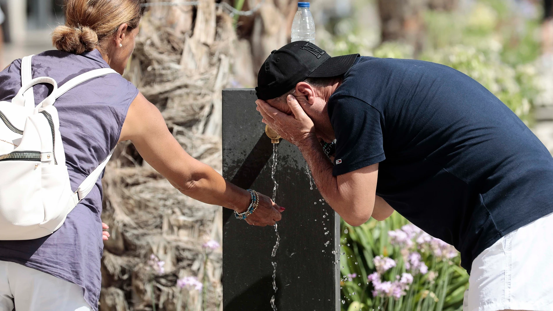 Dos personas se refrescan en una fuente del centro de Valencia