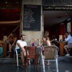 Varias personas sentadas en terrazas en la plaza dels Àngels del Raval