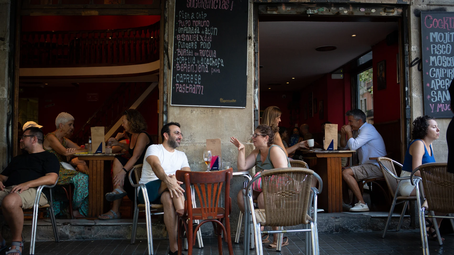 Varias personas sentadas en terrazas en la plaza dels Àngels del Raval