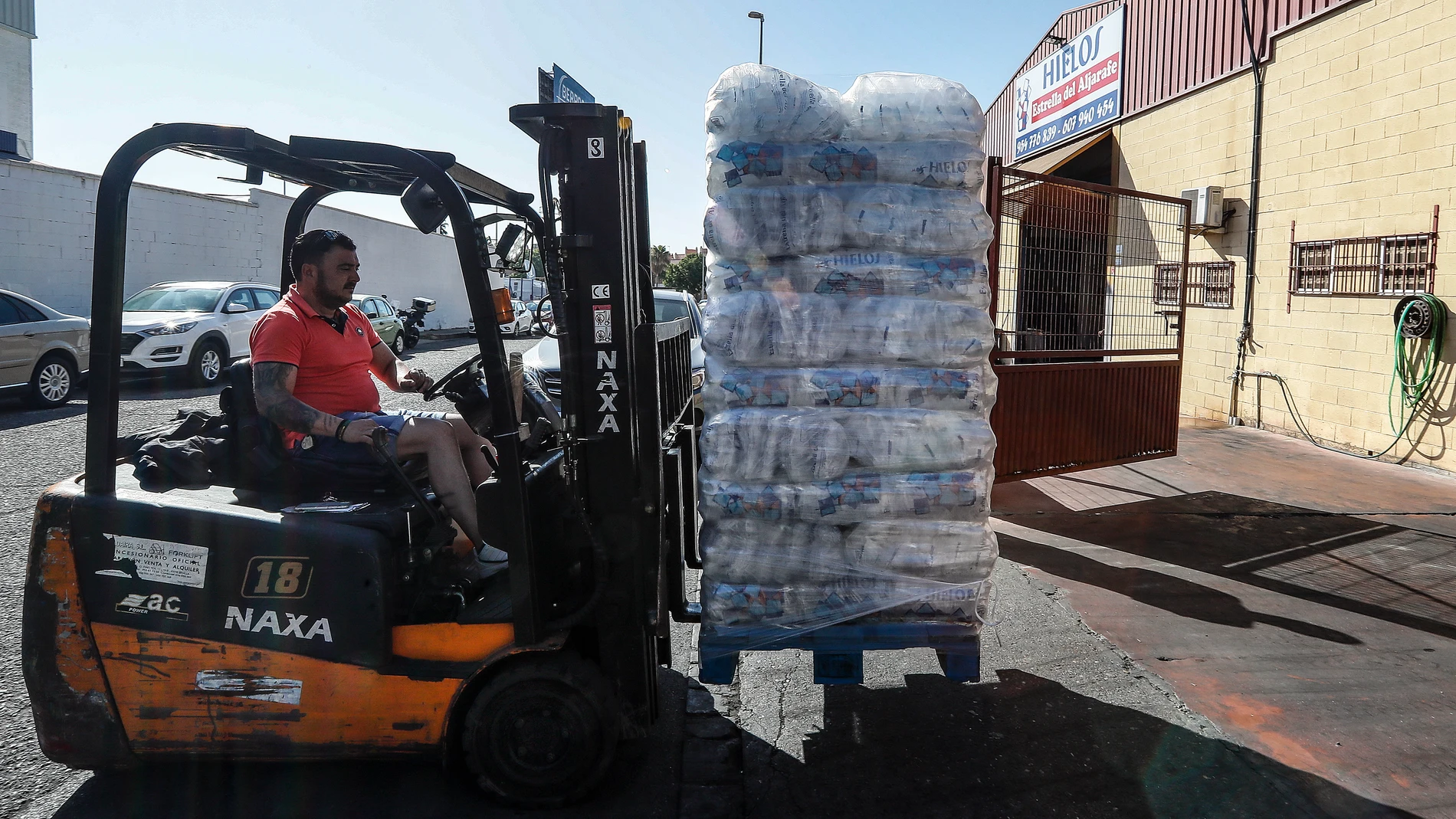 Un trabajador transporta sacos de hielo listos para su consumo en una fábrica de cubitos. EFE/ José Manuel Vidal
