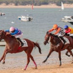 Tres jockeys pelean por la victoria durante una de las pruebas celebradas este martes en Sanlúcar de Barrameda