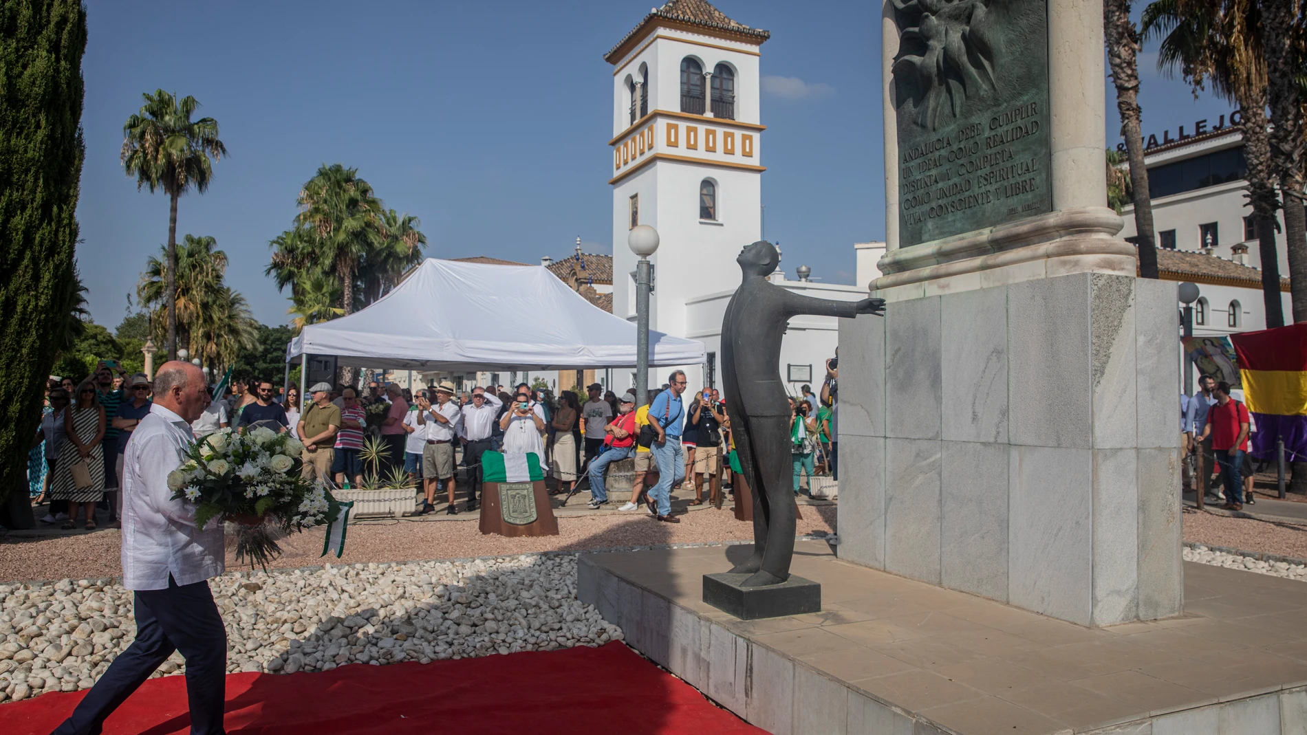 Javier Delmás Infante, sobrino de Blas Infante, deposita un ramo de flores ante el monumento a su abuelo