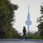 Ciudadanos pasan con el pirulí de fondo por una de las calles de Madrid con el ambiente de neblina debido a los incendios de Portugal. El centro de emergencias 112 de la Comunidad de Madrid ha recibido a lo largo de la mañana de este martes 360 llamadas de ciudadanos alertados por olor a incendio y humo en diferentes puntos de la región, un hecho que se debe a un incendio activo en Portugal.