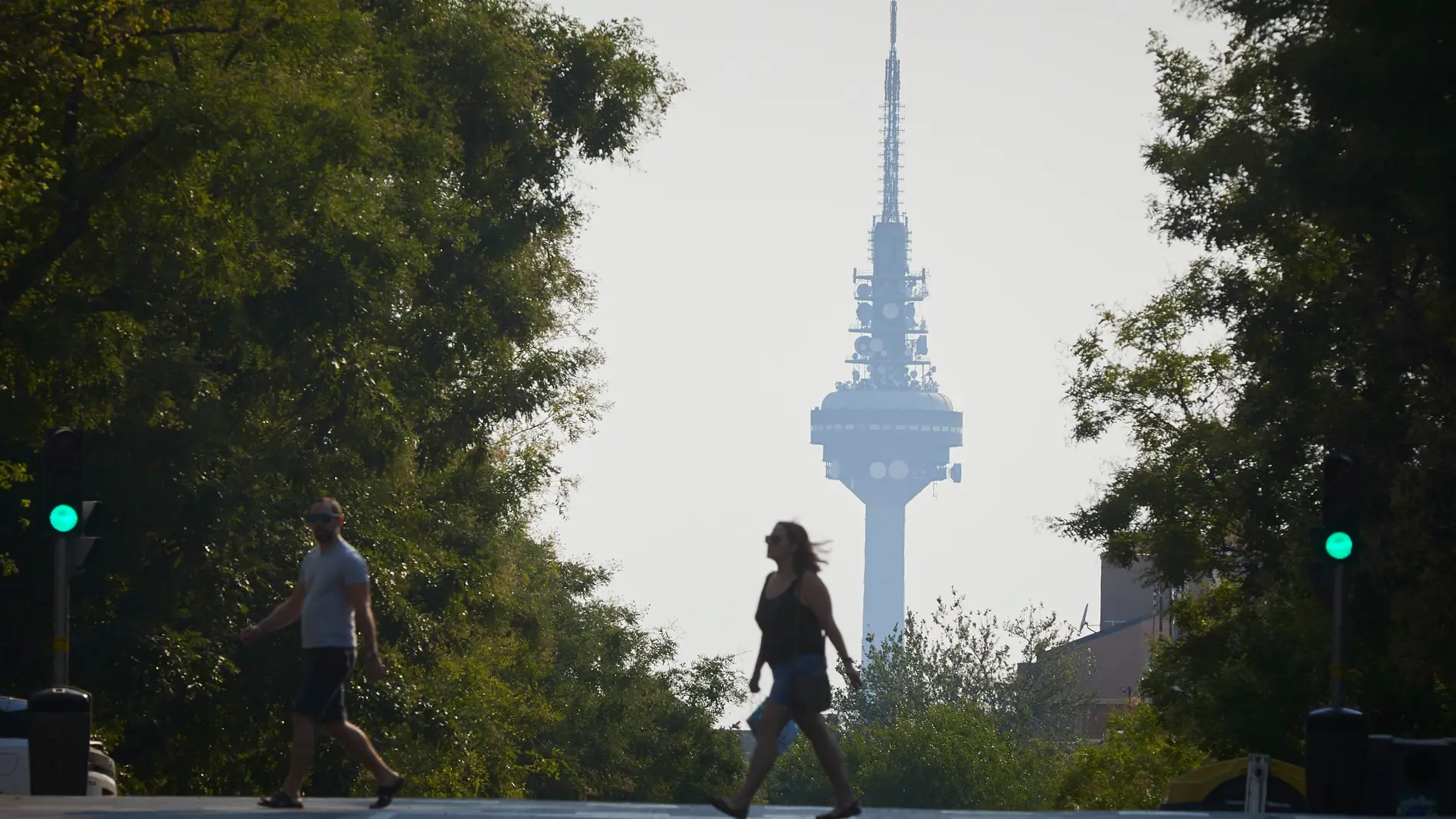 Ciudadanos pasan con el pirulí de fondo por una de las calles de Madrid con el ambiente de neblina debido a los incendios de Portugal. El centro de emergencias 112 de la Comunidad de Madrid ha recibido a lo largo de la mañana de este martes 360 llamadas de ciudadanos alertados por olor a incendio y humo en diferentes puntos de la región, un hecho que se debe a un incendio activo en Portugal.