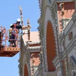 Unos operarios ultiman el montaje del alumbrado en la portada ubicada en el recinto ferial de Almería