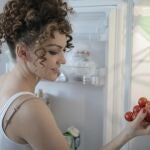 Mujer sacando tomates de la nevera