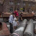 Una familia observa la curiosa exposición de armamento ruso destruido en el centro de Kyiv