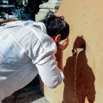 Una persona se refresca en una fuente, en Casa de Campo,