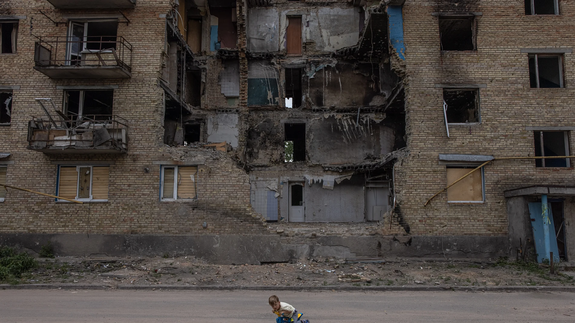 Un niño juega frente a un edificio residencial destruido en Horenka, en la región de Kyiv