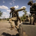 Militares ucranianos del equipo de reconocimiento "Luciérnagas" saltan del maletero de una camioneta para tomar su posición en la línea del frente en la región de Mykolaiv