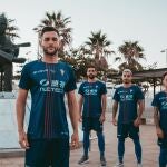 Varios jugadores del Algeciras posan con el nuevo uniforme junto a la estatua de Paco de Lucía