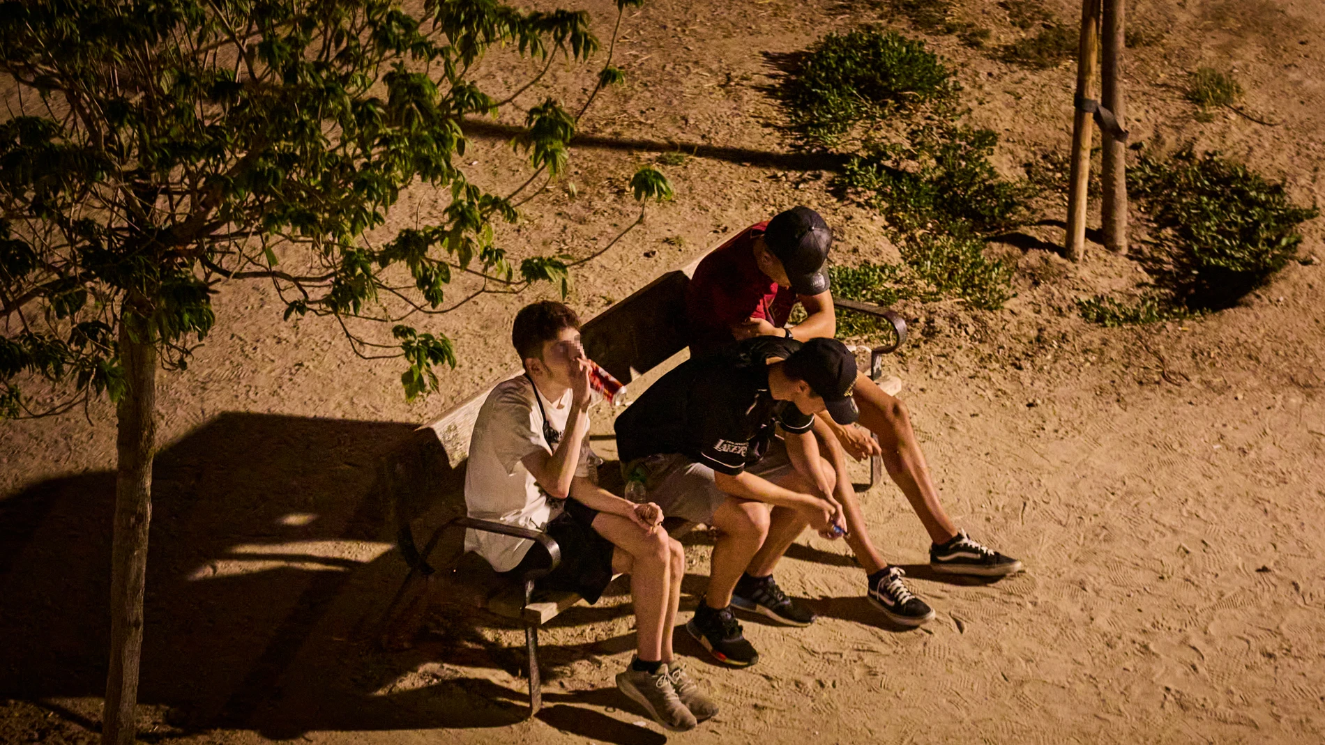 Jóvenes bebiendo en la calle en un parque en Madrid.