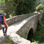 Un peregrino atravesando un puente. 