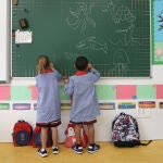 Dos niños pintan en una pizarra