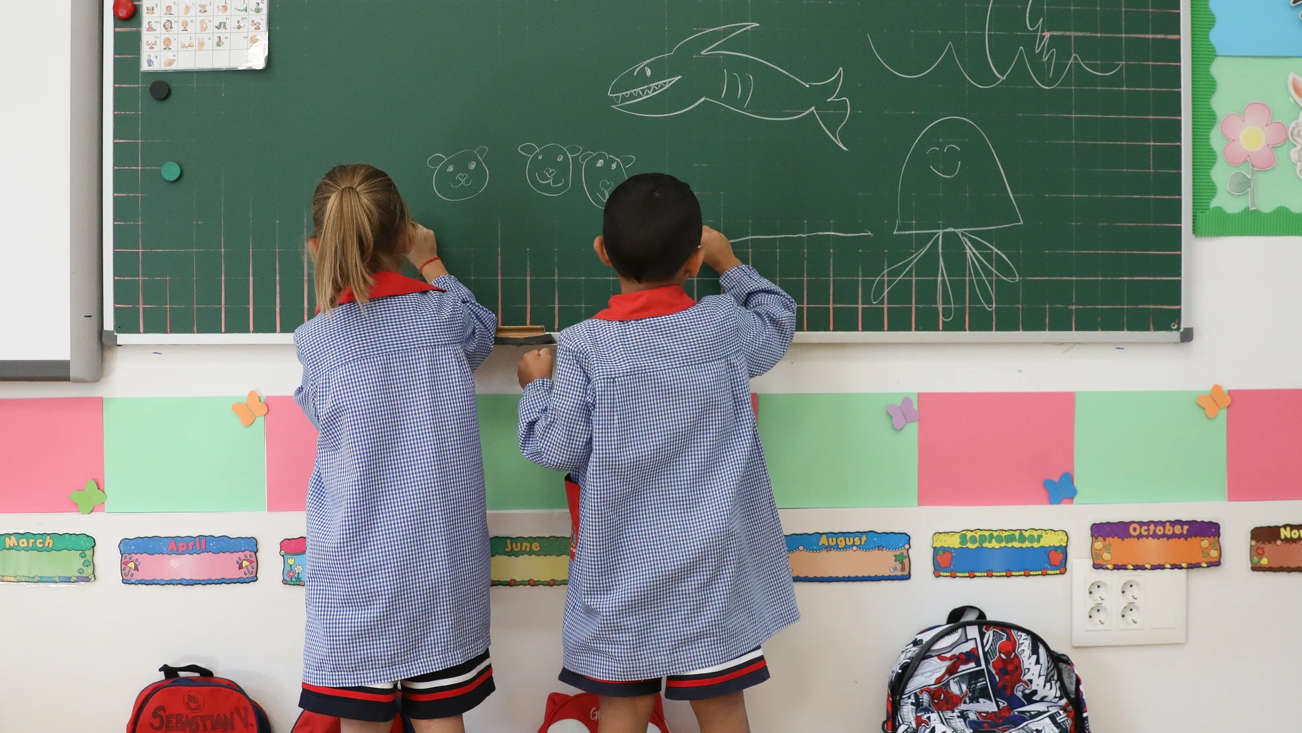 Dos niños pintan en una pizarra