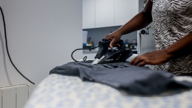 Una empleada de hogar plancha una camiseta, el día en que han aprobado el paro para las empleadas del hogar