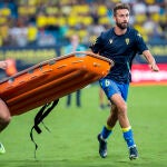 El centrocampista del Cádiz CF, José Mari transporta una camilla hacia la grada donde se encuentra un aficionado enfermo un durante el partido de LaLiga que enfrenó al Cádiz CF y al Barcelona CF en el estadio Nuevo Mirandilla de Cádiz este sábado. EFE/Román Ríos.