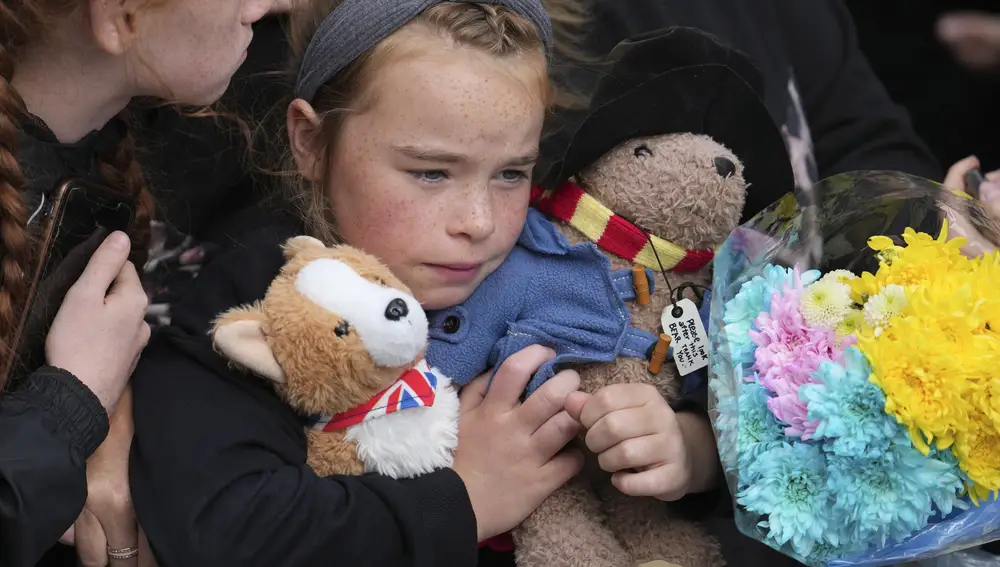 Una niña, abrazando a su osito Paddington a la espera de la procesión del féretro de Isabel II. (AP Photo/Jon Super, Pool)