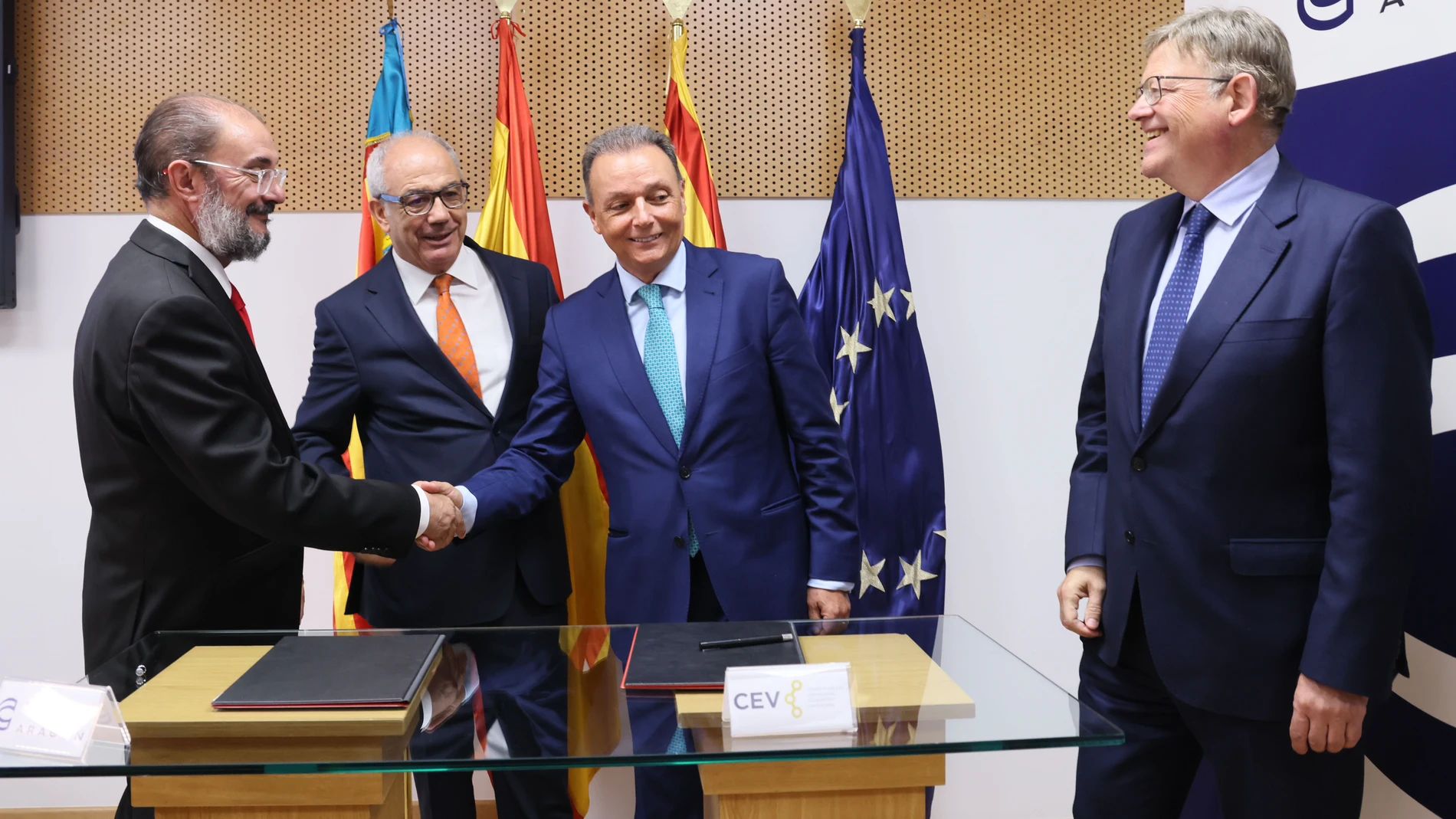 Javier Lambán (i), presidente del Gobierno de Aragón, y Ximo Puig (d), presidente de la Generalitat Valenciana, se dan la mano en presencia de Miguel Marzo (2i), presidente de CEOE Aragón y Salvador Navarro, presidente de CEV, durante el acto de clausura del Foro Impulso al Corredor Cantábrico-Mediterráneo