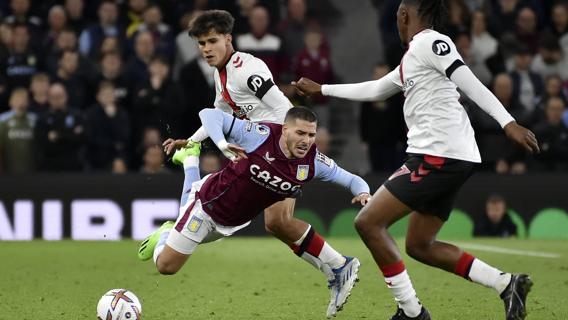 Juan Larios (c) trata de recuperar el balón ante la caída del jugador del Aston Villa. AP Photo/Rui Vieira