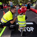 Un agente del Ayuntamiento junto a un pequeño en bicicleta, durante el acto central de la Semana de la Movilidad en el centro de la capital