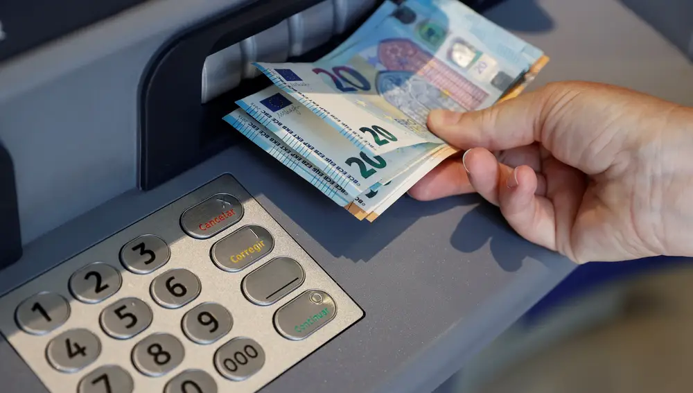 Una persona saca dinero del cajero